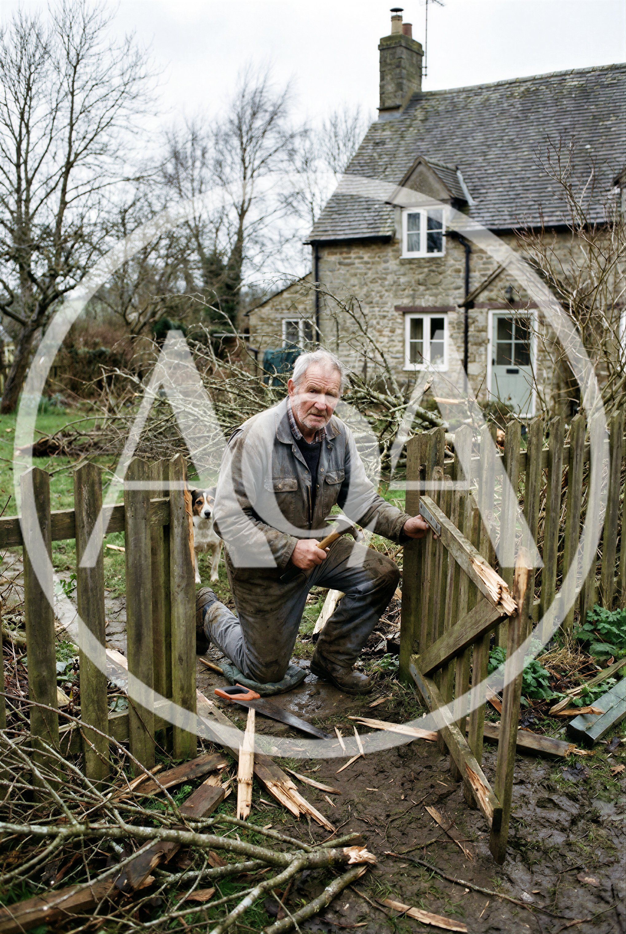 Elderly Man Repairing Broken Wooden Garden Gate
