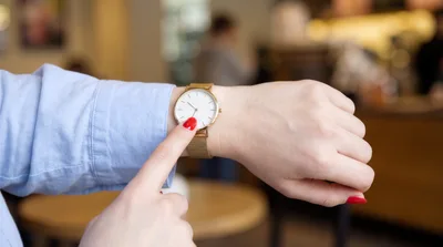 Woman Pointing At Her Gold Wristwatch