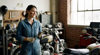 Female Mechanic Holding Wrench In Motorcycle Workshop