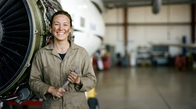 Female Aircraft Mechanic Holding Wrench In Hangar