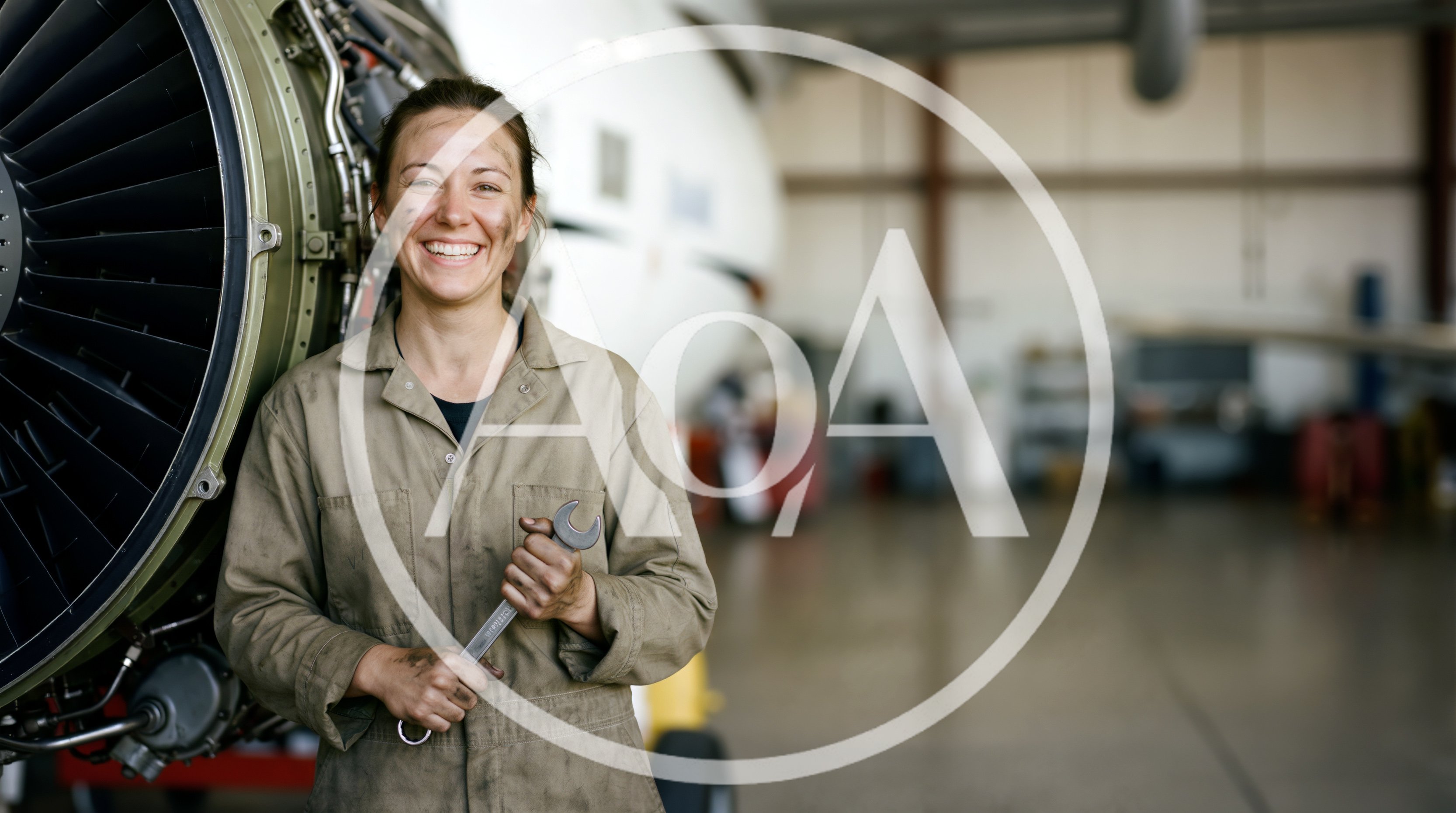 Female Aircraft Mechanic Holding Wrench In Hangar