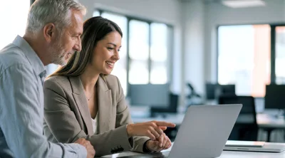 Professional Business Colleagues Collaborating on Laptop in Office