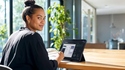 Young Woman Working On Digital Tablet In Bright Office