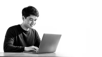 Young Asian Man Working On Laptop Computer