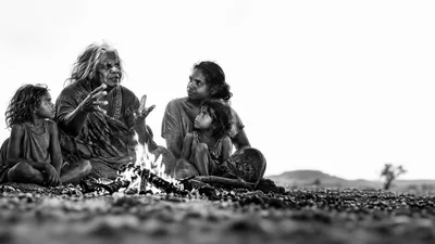Indigenous Australian Family Gathering Around A Campfire