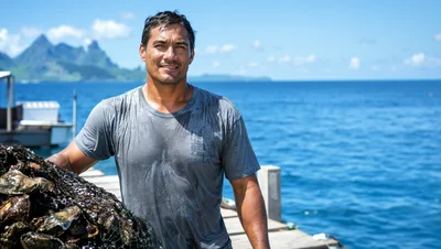 Pearl Farmer Holding Oyster Net on Tropical Dock