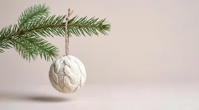 Knitted Christmas Ornament Hanging From Pine Branch