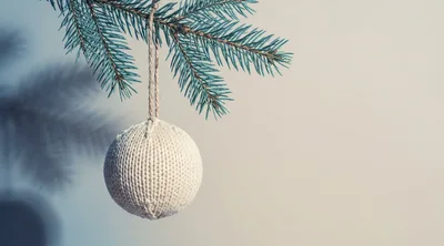 Knitted Christmas Ornament Hanging From A Pine Branch