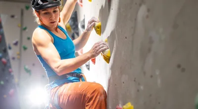 Female Rock Climber Scaling Indoor Climbing Wall