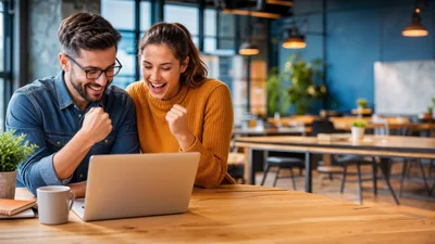 Excited Couple Celebrating Success While Working On Laptop