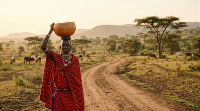 Maasai Woman Carrying Calabash on Head in Savannah