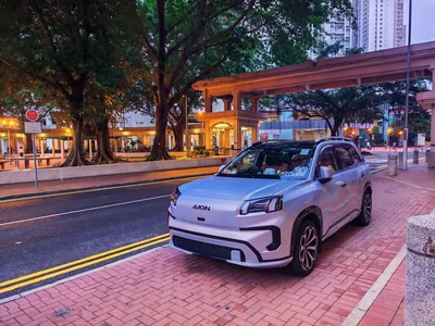 Silver Aion Electric SUV Parked on City Sidewalk