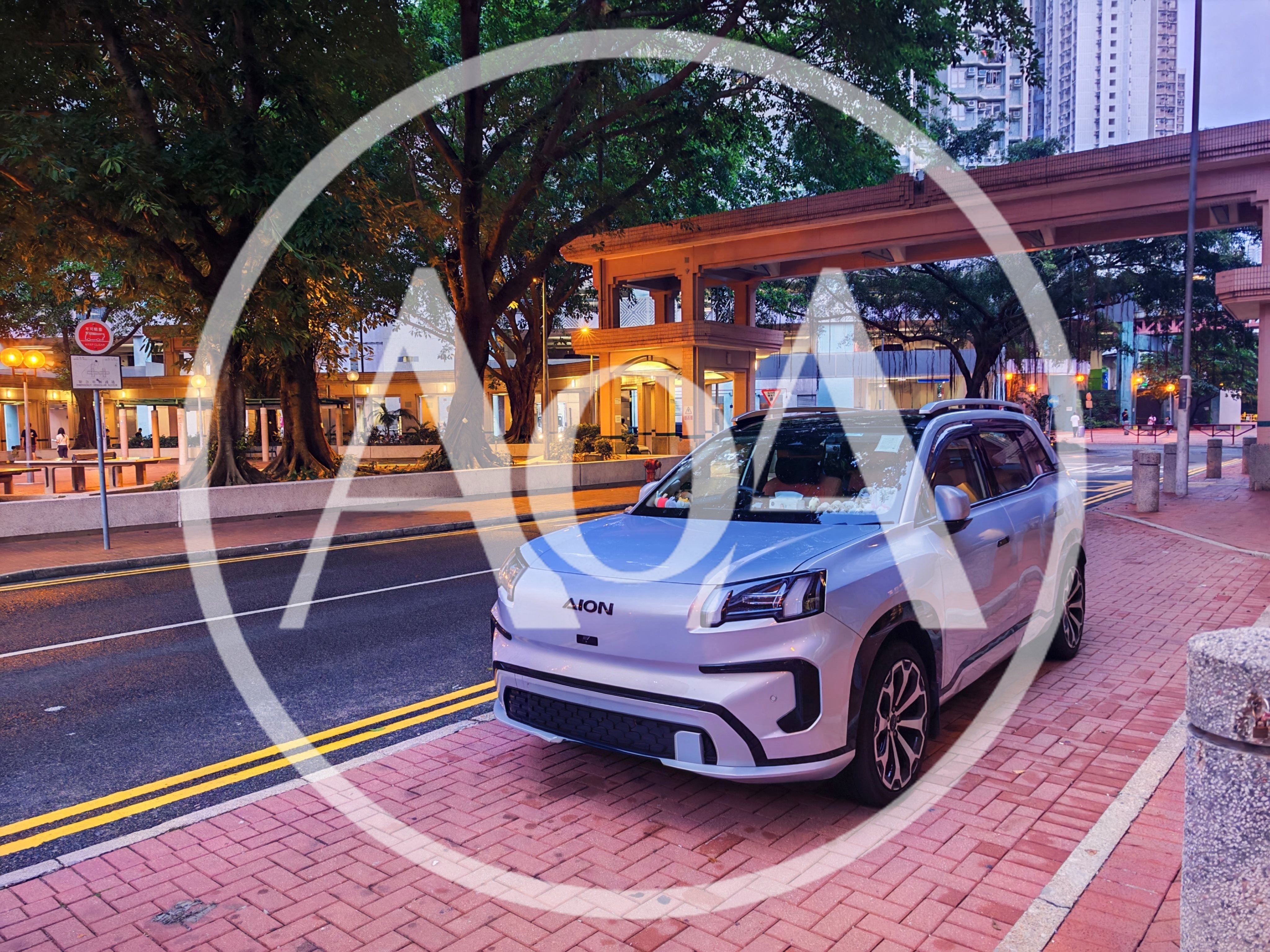 Silver Aion Electric SUV Parked on City Sidewalk