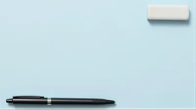 Black Pen and White Eraser on Light Blue Background