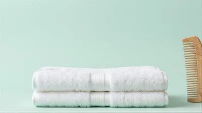 Stacked White Towels and Wooden Comb