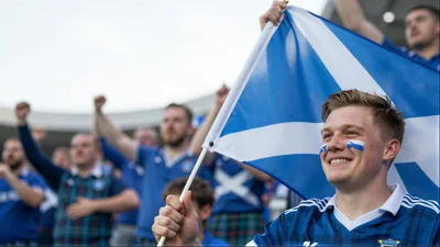 Scottish Football Fans Cheering With Flag In Stadium