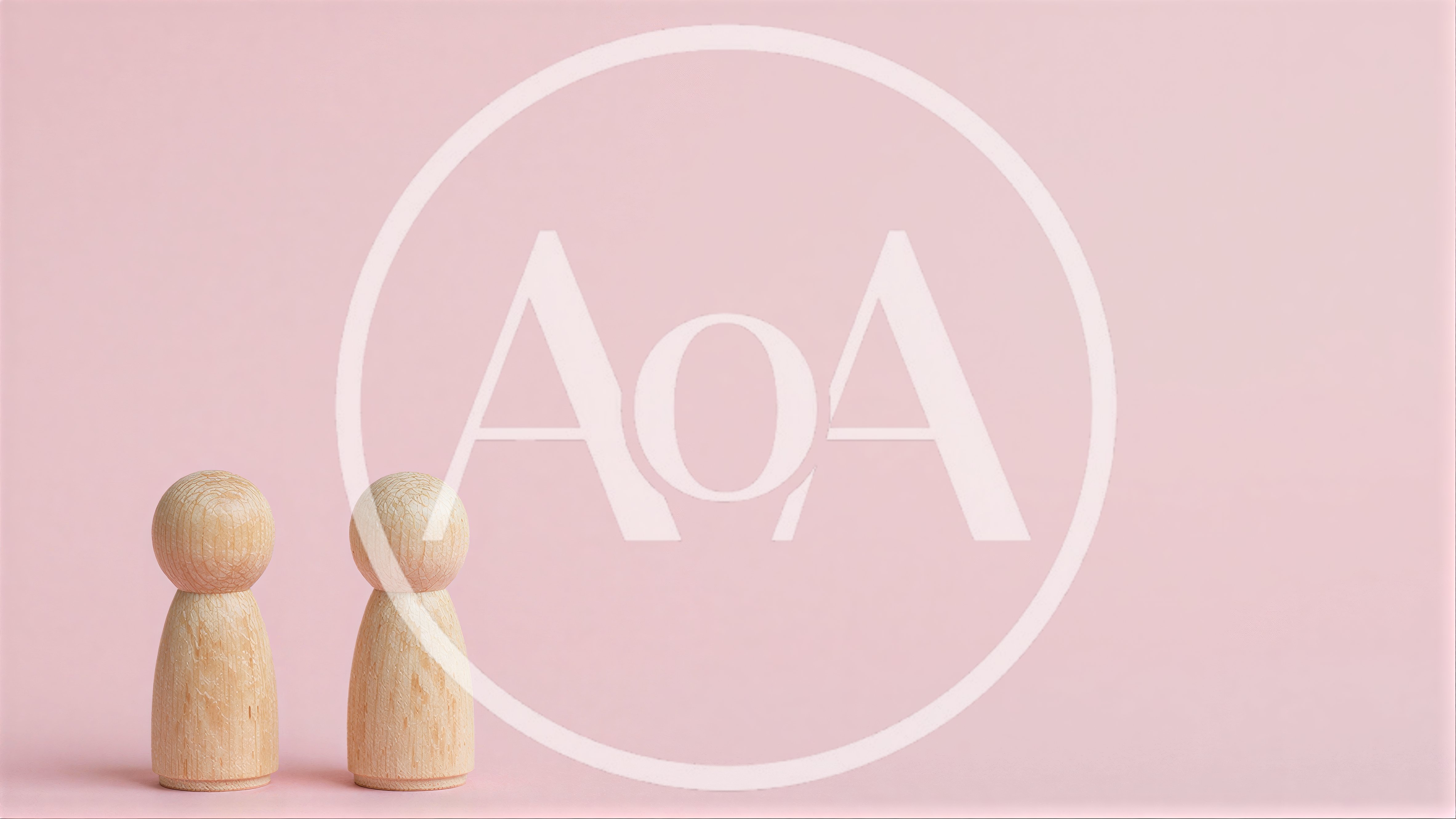 Two Wooden Peg Dolls Standing On Pink Background