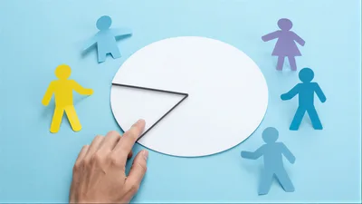 Hand Adjusting A Paper Pie Chart With Paper People