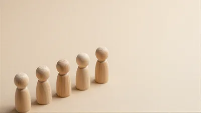 Five Wooden Peg Dolls Arranged In A Row