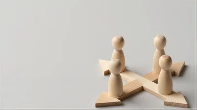 Wooden Peg Figures Standing On Intersecting Arrows