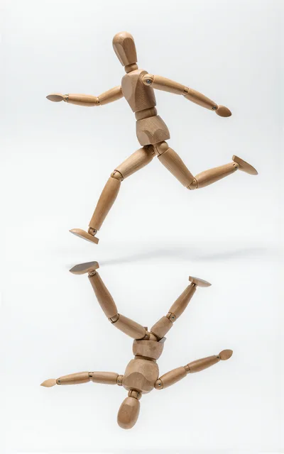 Wooden Mannequin Jumping With Its Reflection