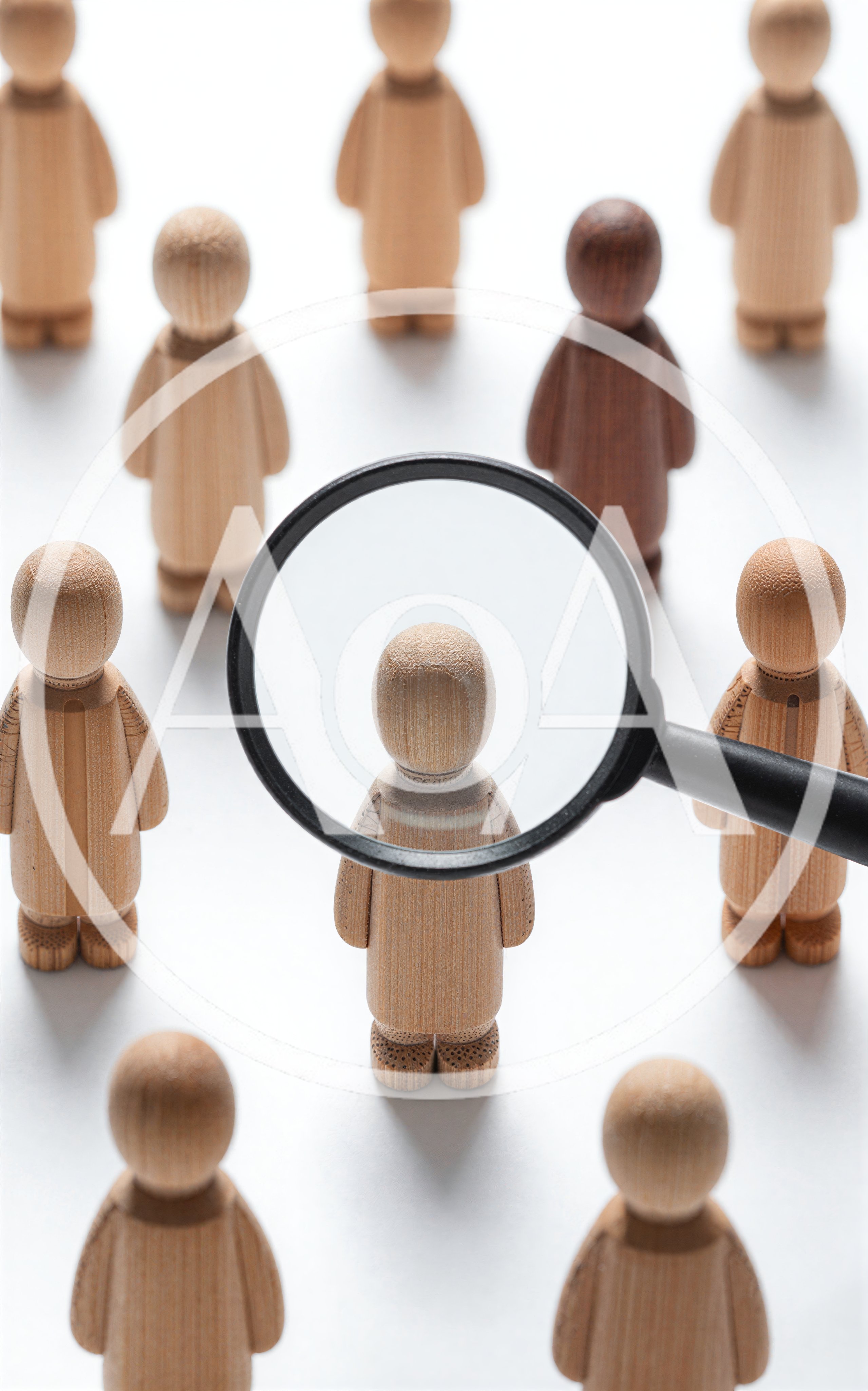 Magnifying Glass Focusing On A Single Wooden Figurine