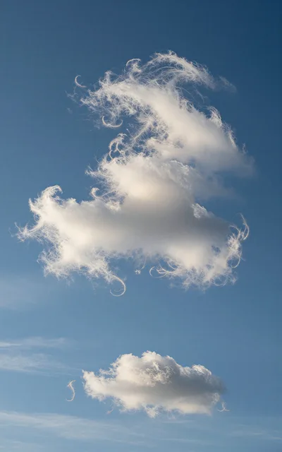 Surreal Clouds With Feather Like Wisps In Blue Sky