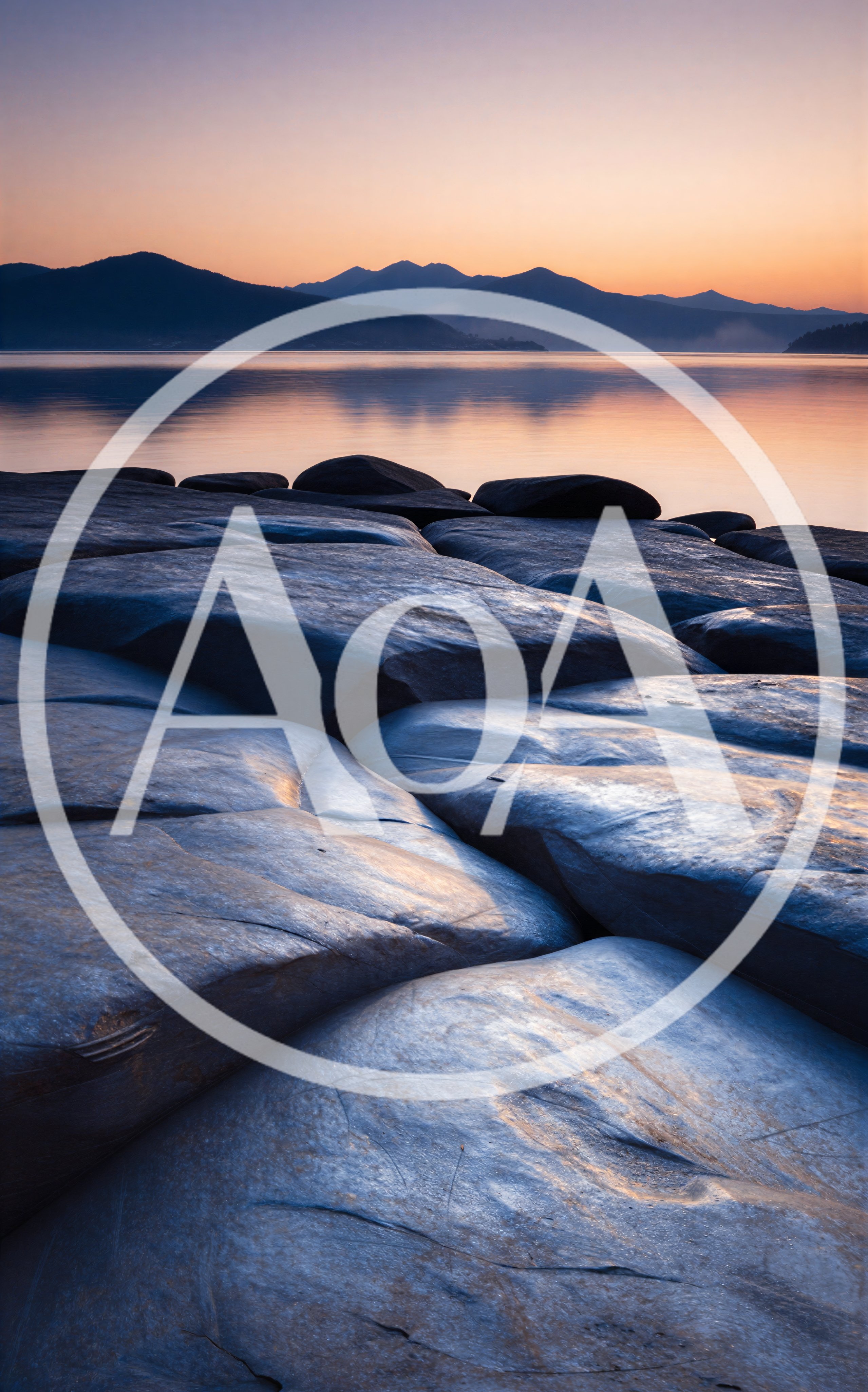 Smooth Coastal Rocks At Sunset Over Calm Lake