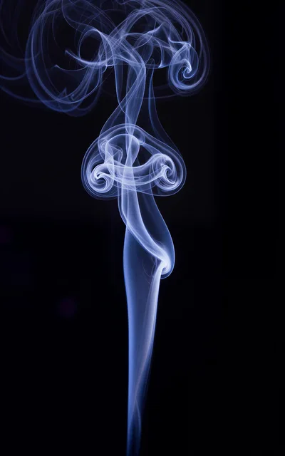 Abstract Blue Smoke Swirls Against Black Background