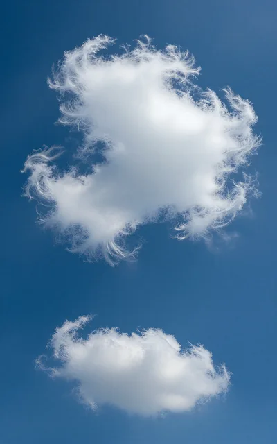 Two Wispy White Clouds Against A Clear Blue Sky
