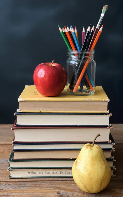 Stack Of Books With Apple And Pear On Table