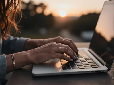 Woman Typing On Laptop During Golden Hour Sunset