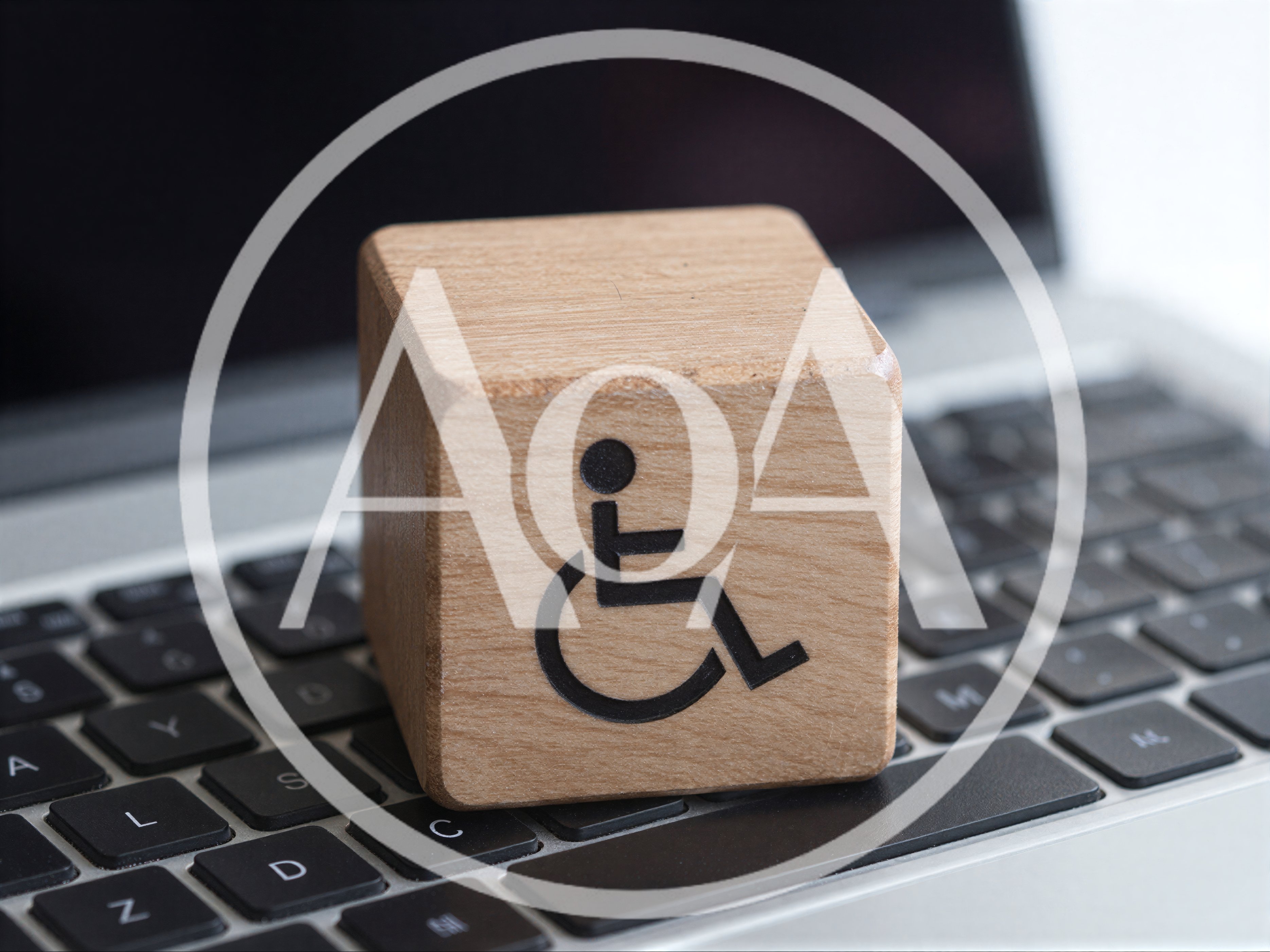 Wooden Block With Disability Symbol On Laptop Keyboard