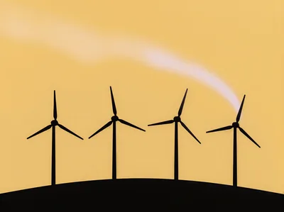 Silhouette Of Four Wind Turbines Against A Golden Sky
