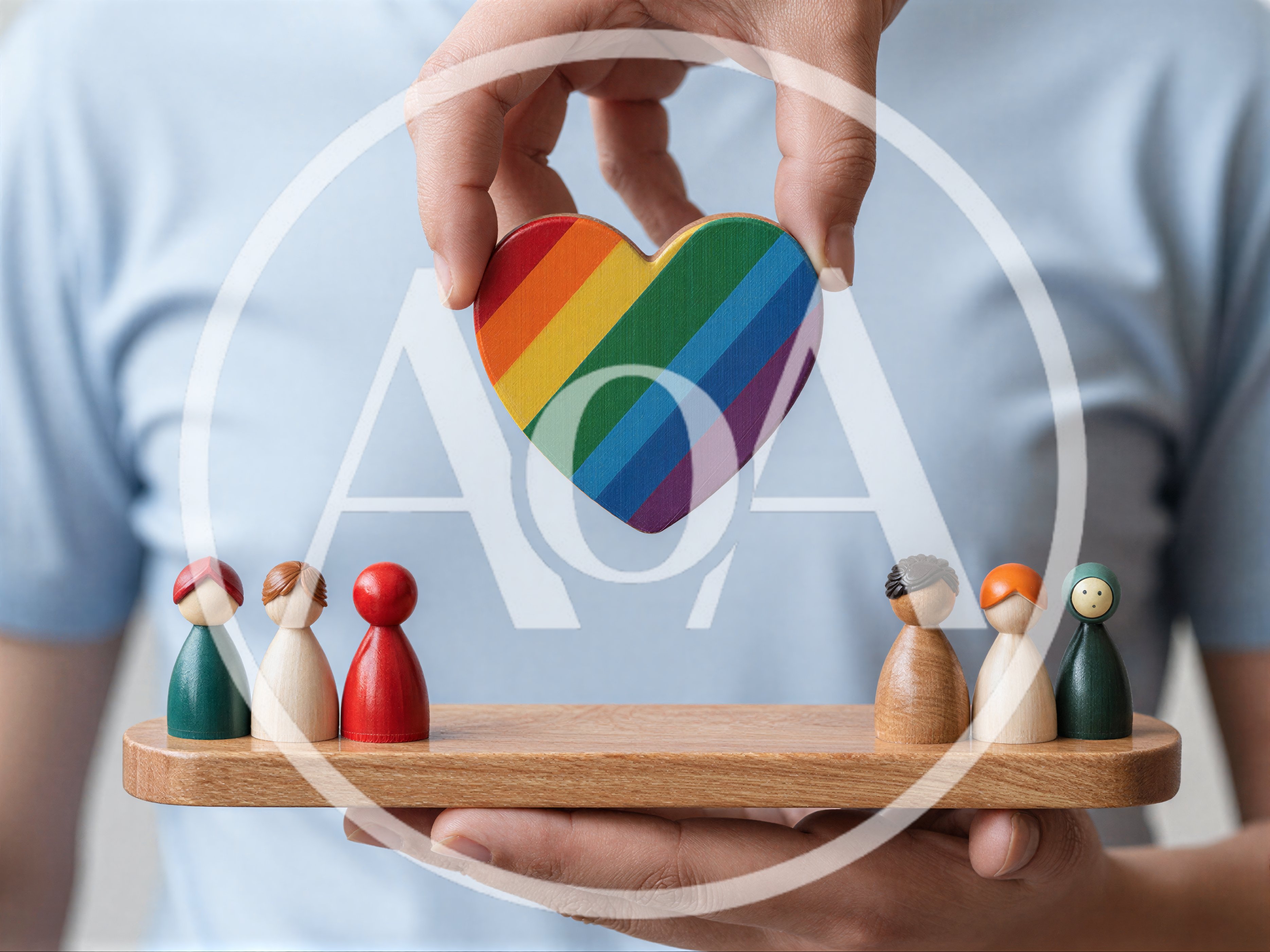 Person Holding Rainbow Heart Above Wooden Peg Figures