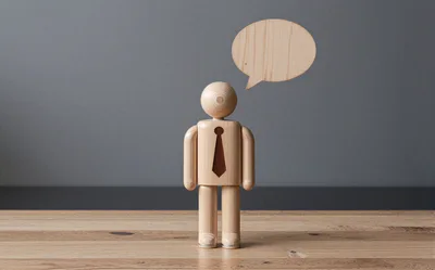 Wooden Mannequin Figure With Speech Bubble On Table