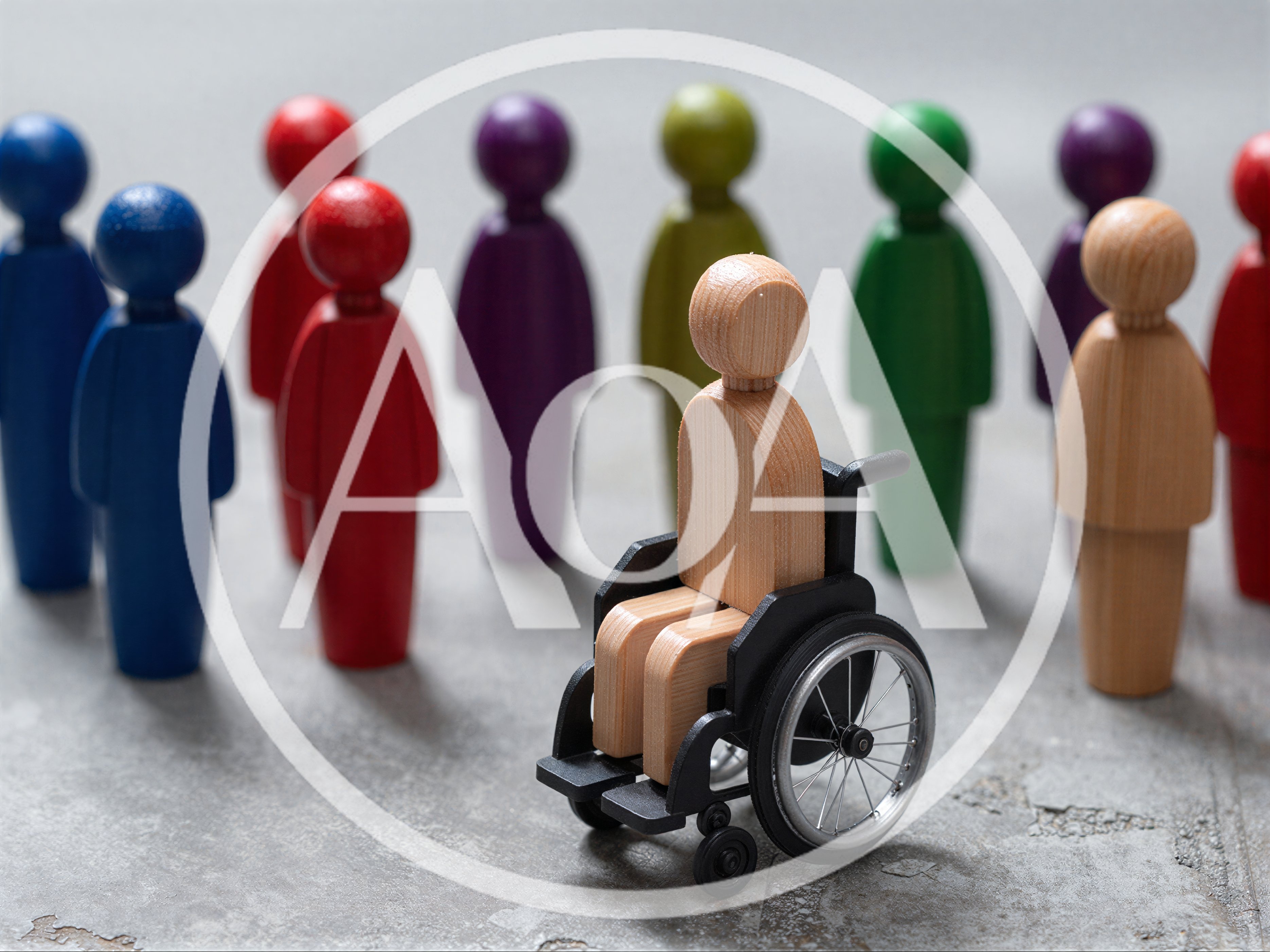 Wooden Figure in Wheelchair Surrounded by Colorful Figurines