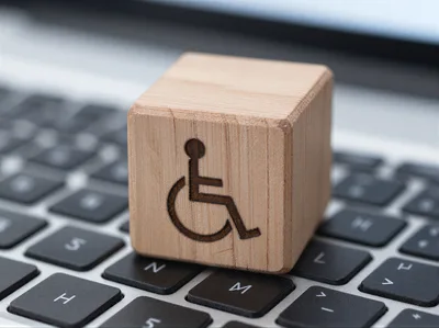 Wooden Block With Disability Symbol On Laptop Keyboard