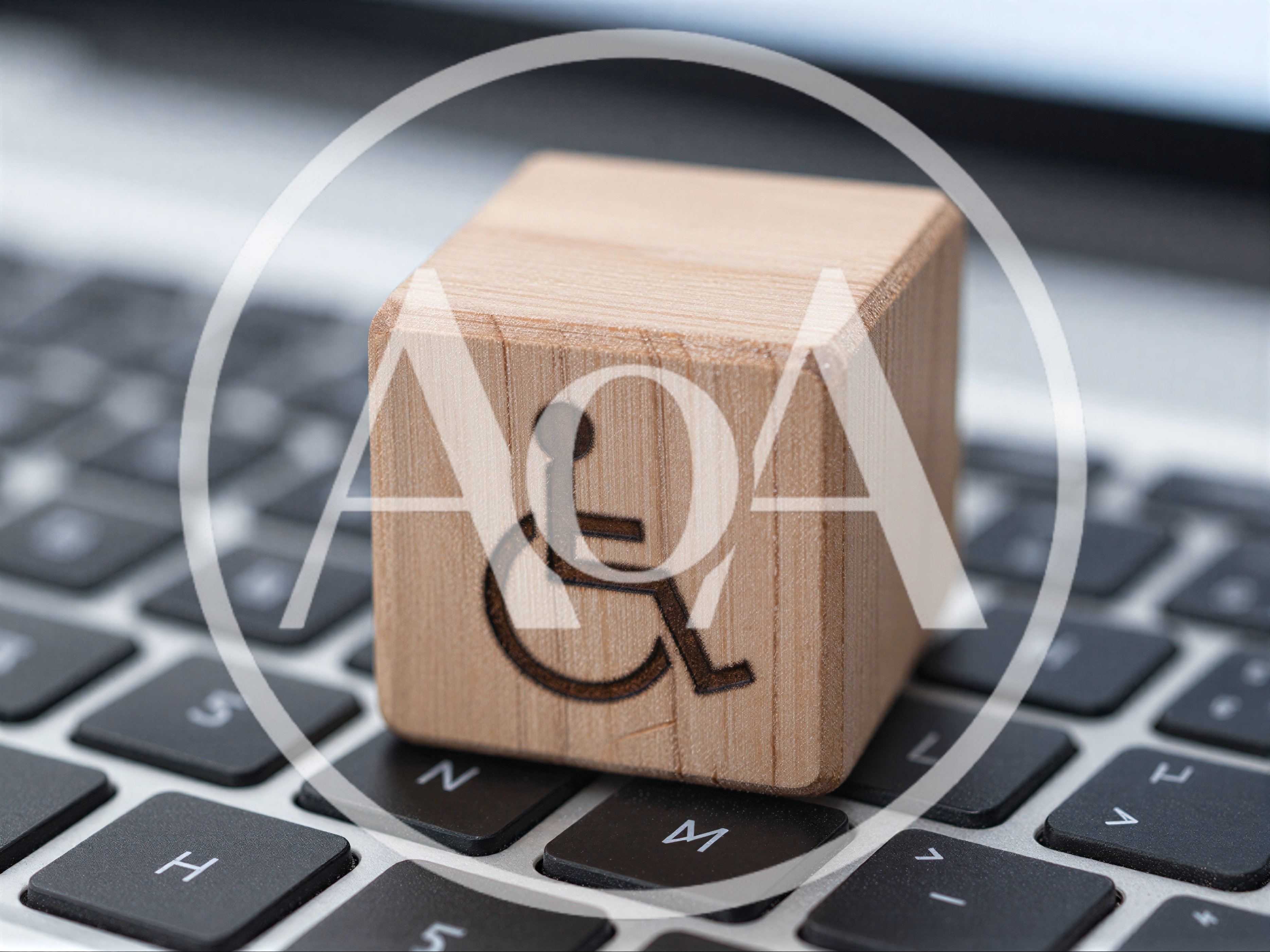 Wooden Block With Disability Symbol On Laptop Keyboard