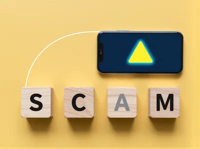 Smartphone With Warning Icon And Wooden Scam Blocks