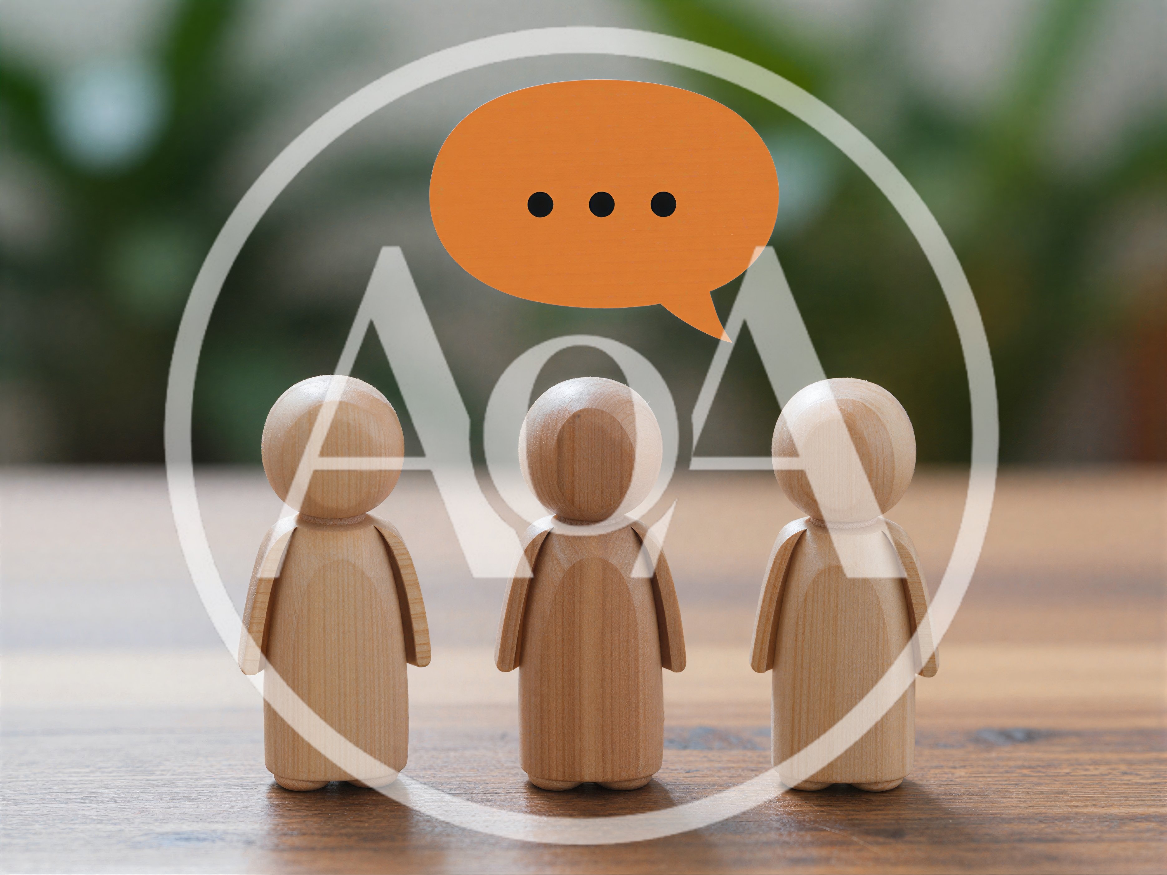 Three Wooden Peg Dolls With An Orange Speech Bubble