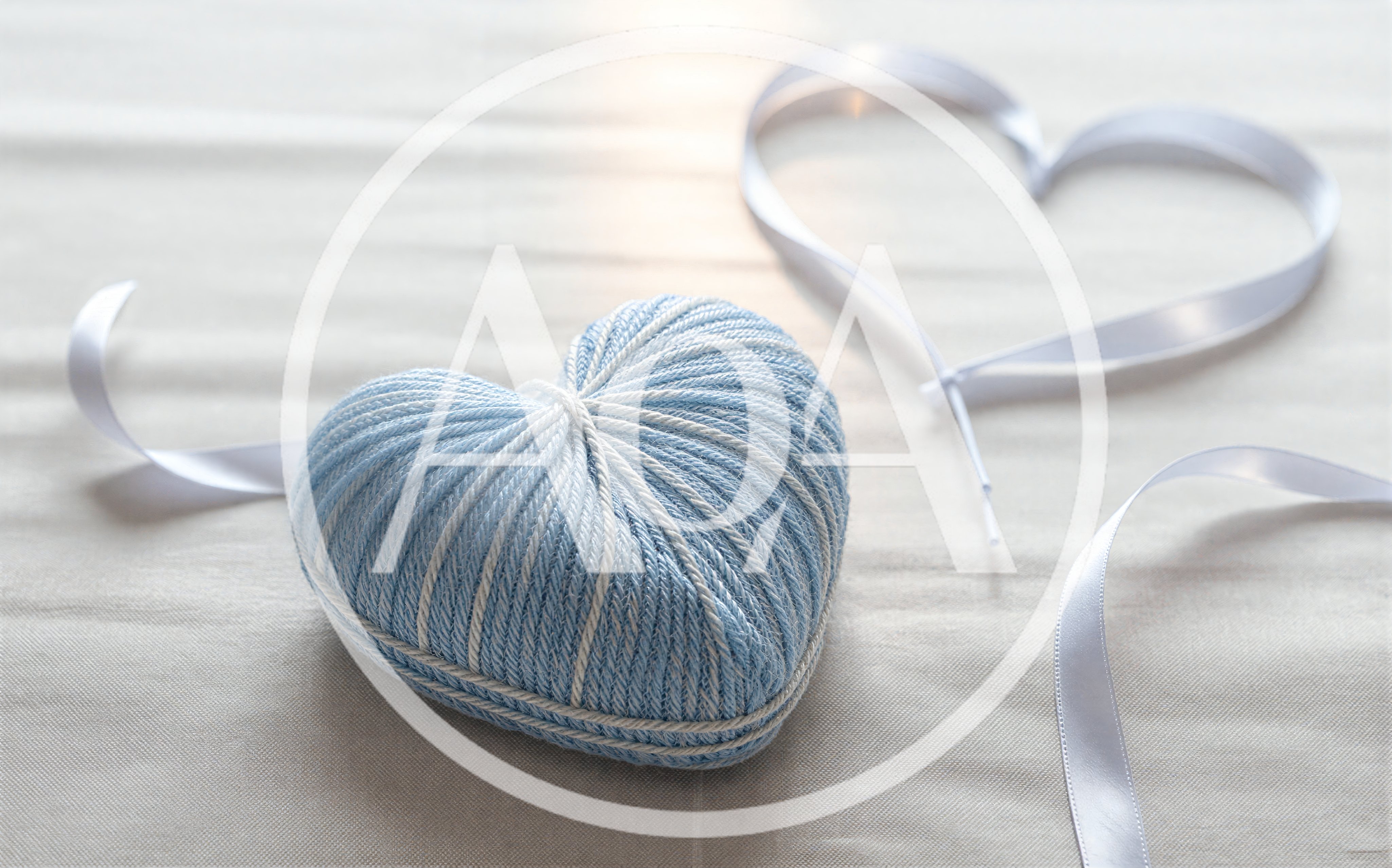 Blue Yarn Heart and White Ribbon on Fabric