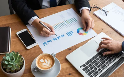 Business Professionals Analyzing Financial Charts At Office Desk