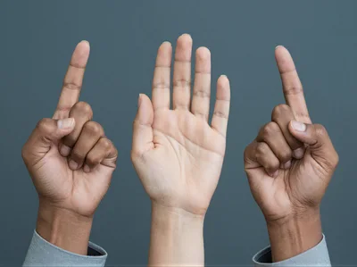 Three Hands Raised Against A Grey Background