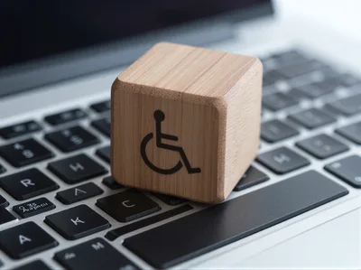 Wooden Block With Disability Symbol On Laptop Keyboard