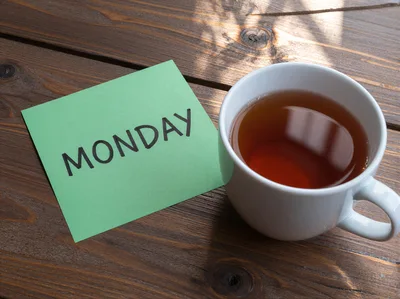 Green Note With Monday Written On Wooden Table