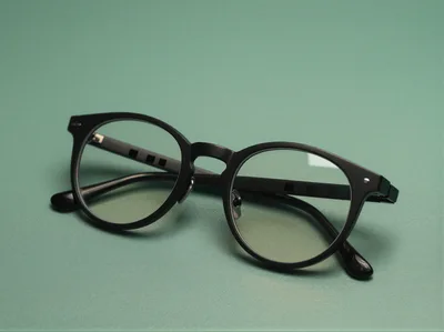 Black Rimmed Eyeglasses On A Green Background