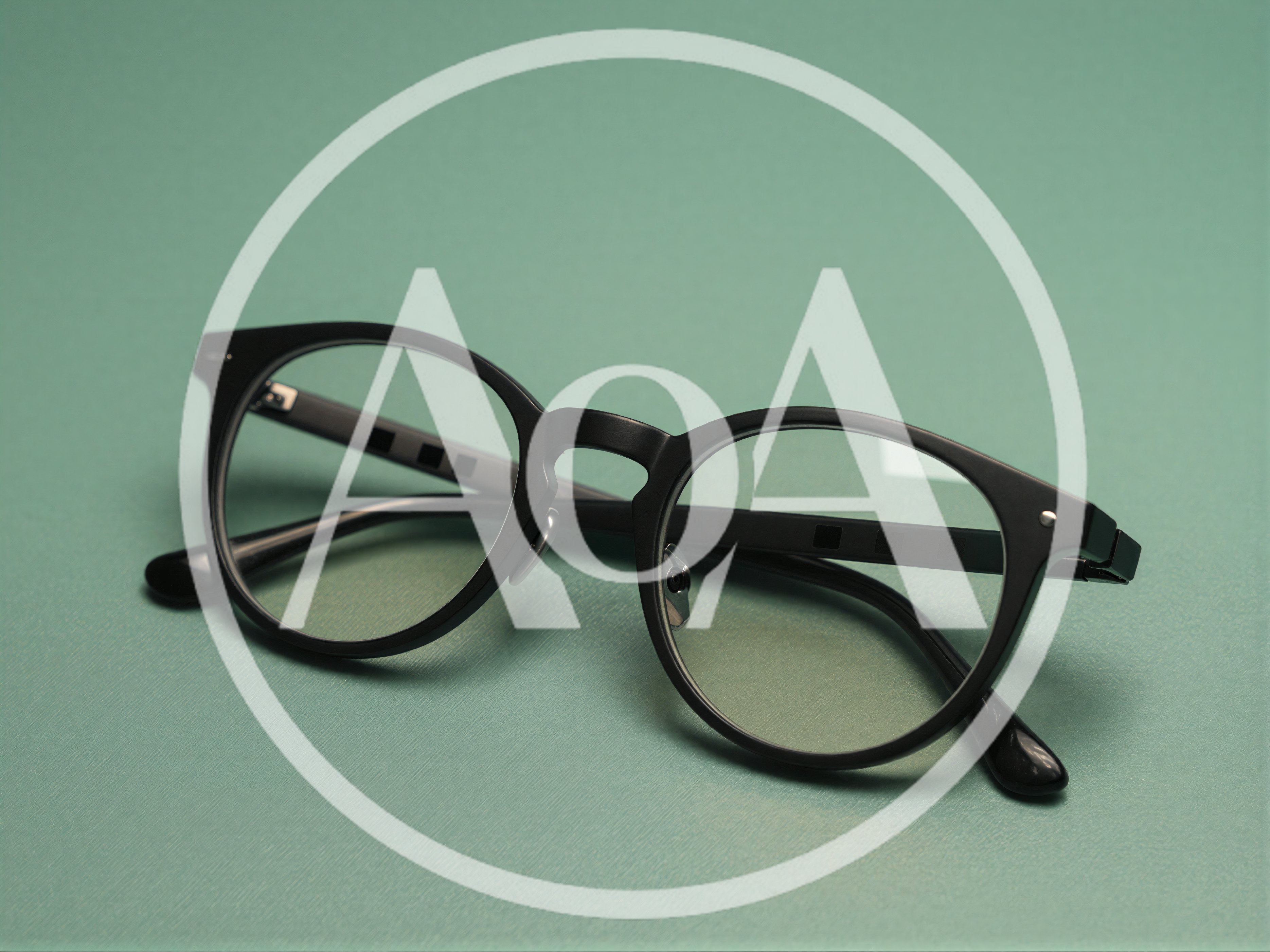 Black Rimmed Eyeglasses On A Green Background