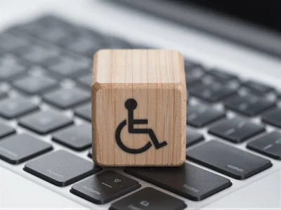 Wooden Block With Accessibility Symbol On Laptop Keyboard