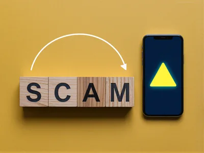 Wooden Blocks Spelling Scam Next To Smartphone With Warning